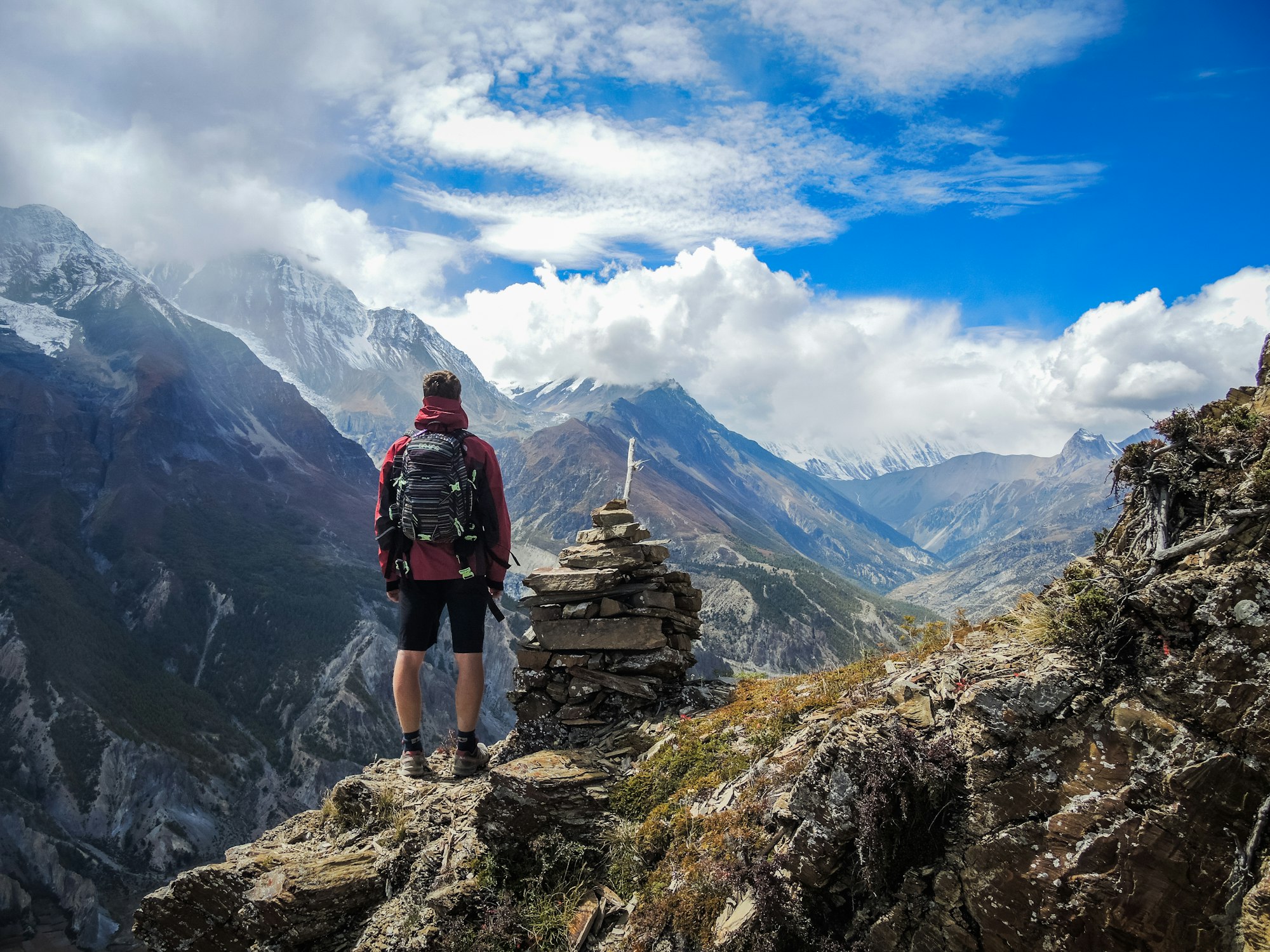 A trekker marking a mountain route with cairn stones