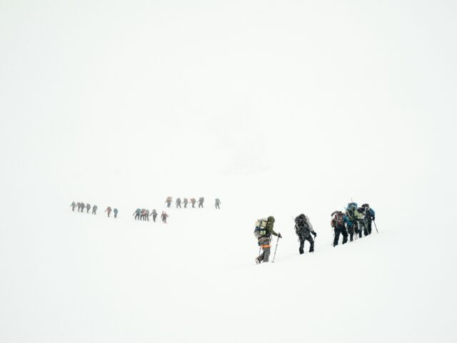 Hiring a guide in northern Pakistan: a guided group crossing a snowy mountain