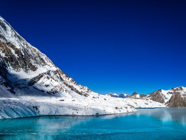 A high-altitude glacial lake surrounded by snow-capped peaks, similar to Rush Lake