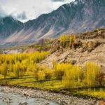 Green and brown mountains in Hunza under white clouds