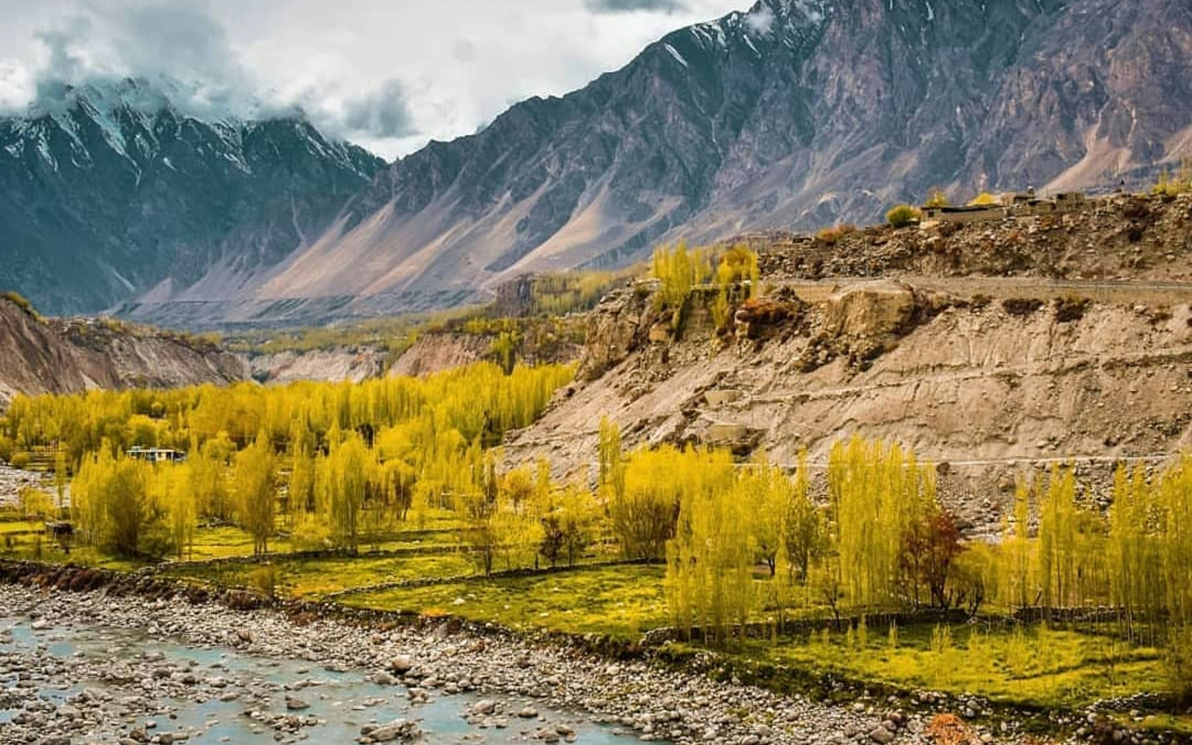 Green and brown mountains in Hunza under white clouds