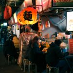 People eating at a lively night market food stall