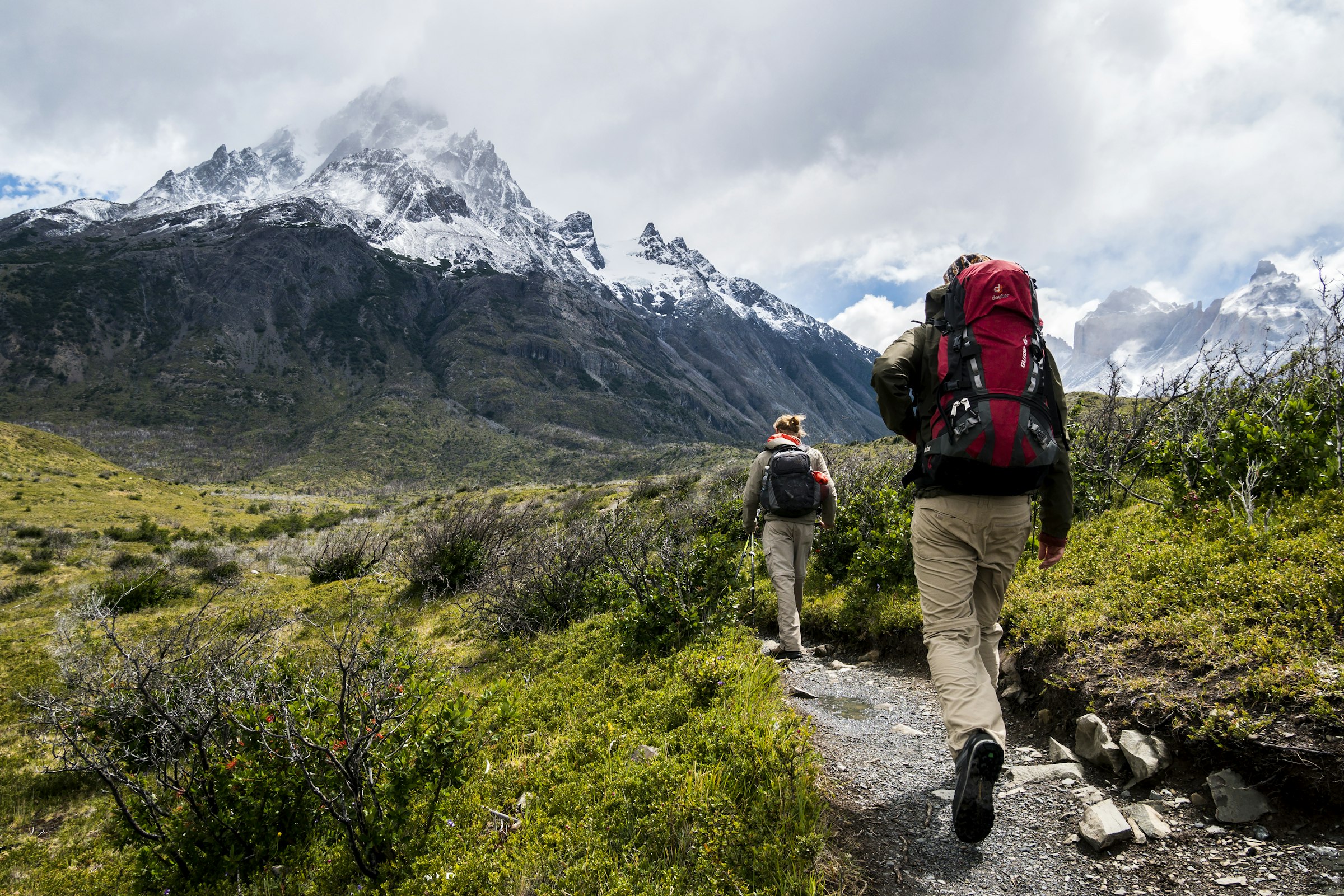 Packing list for northern Pakistan: trekkers walking toward snow-covered mountains