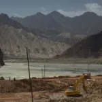 A truck driving down a mountain road along the Karakoram Highway route