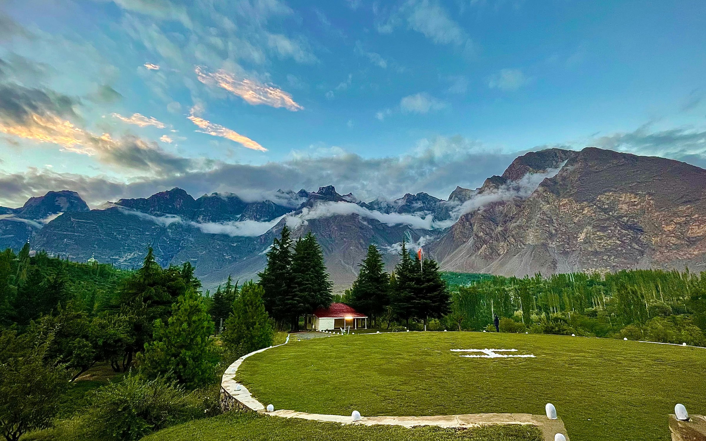 A grassy terraced field with mountains in the background, near Skardu, Pakistan