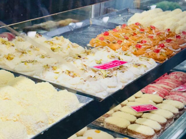 An assortment of colorful mithai sweets displayed in a shop, illustrative of Pakistani desserts
