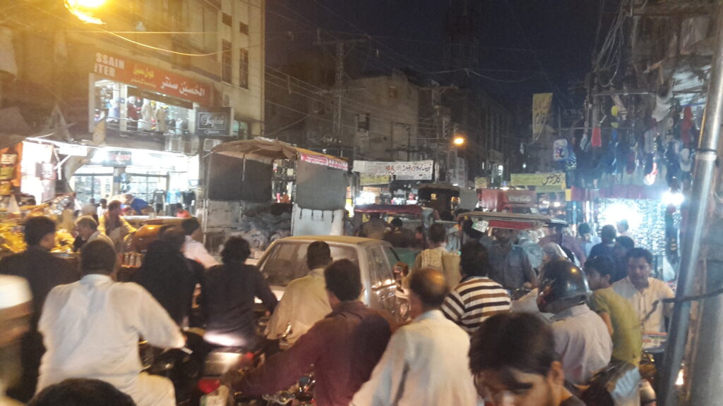 Shoppers and shopfronts on a busy street in Anarkali Bazaar, Lahore