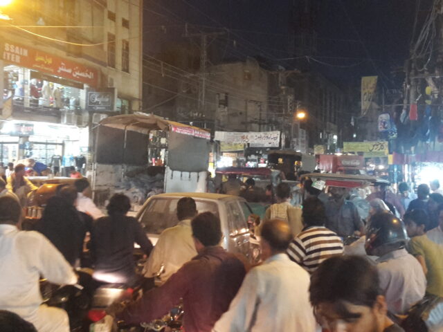 Shoppers and shopfronts on a busy street in Anarkali Bazaar, Lahore