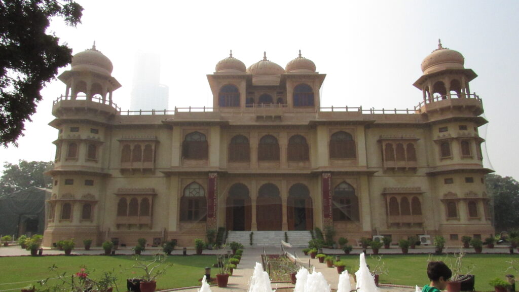Front of Mohatta Palace in Clifton, Karachi, showing its pink and yellow stone domes and facade