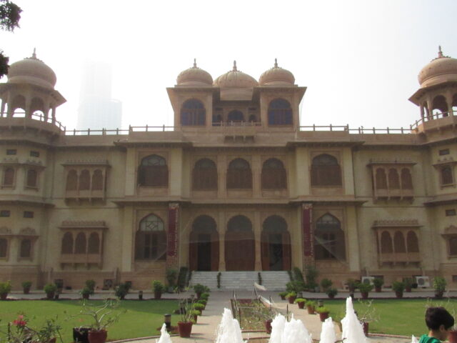 Front of Mohatta Palace in Clifton, Karachi, showing its pink and yellow stone domes and facade