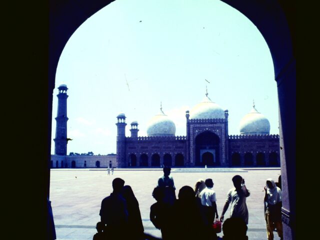 Visitors walking across the courtyard of Badshahi Mosque in Lahore