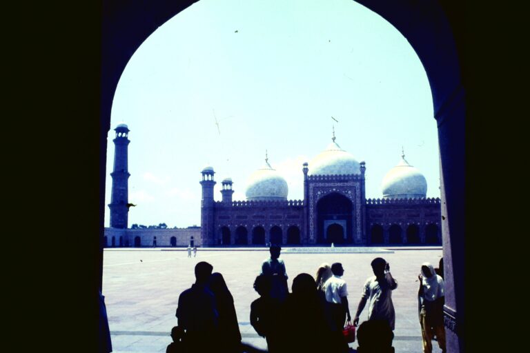 Visitors walking across the courtyard of Badshahi Mosque in Lahore